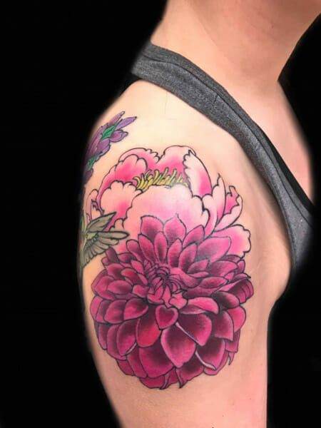 A man with a pink flower tattoo on his shoulder.