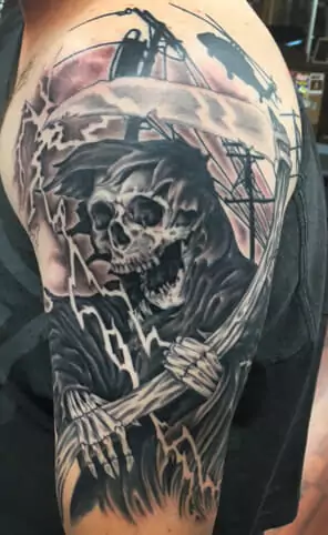 A tattoo of a skeleton holding a scythe.