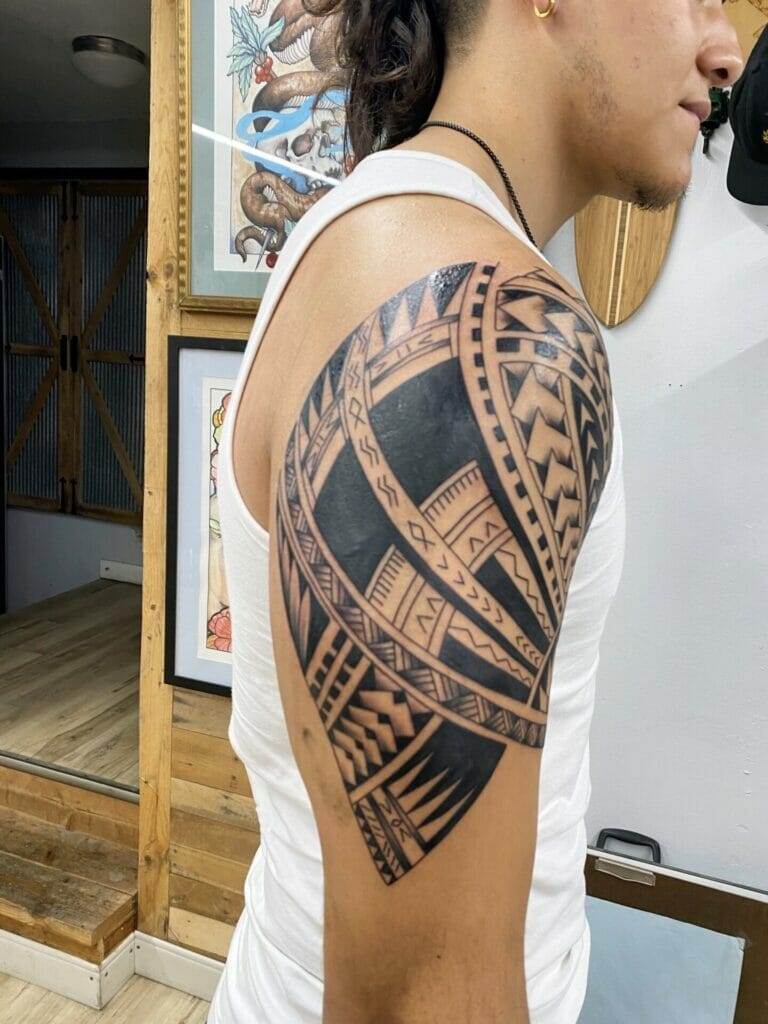 A man with a tribal tattoo on his arm.