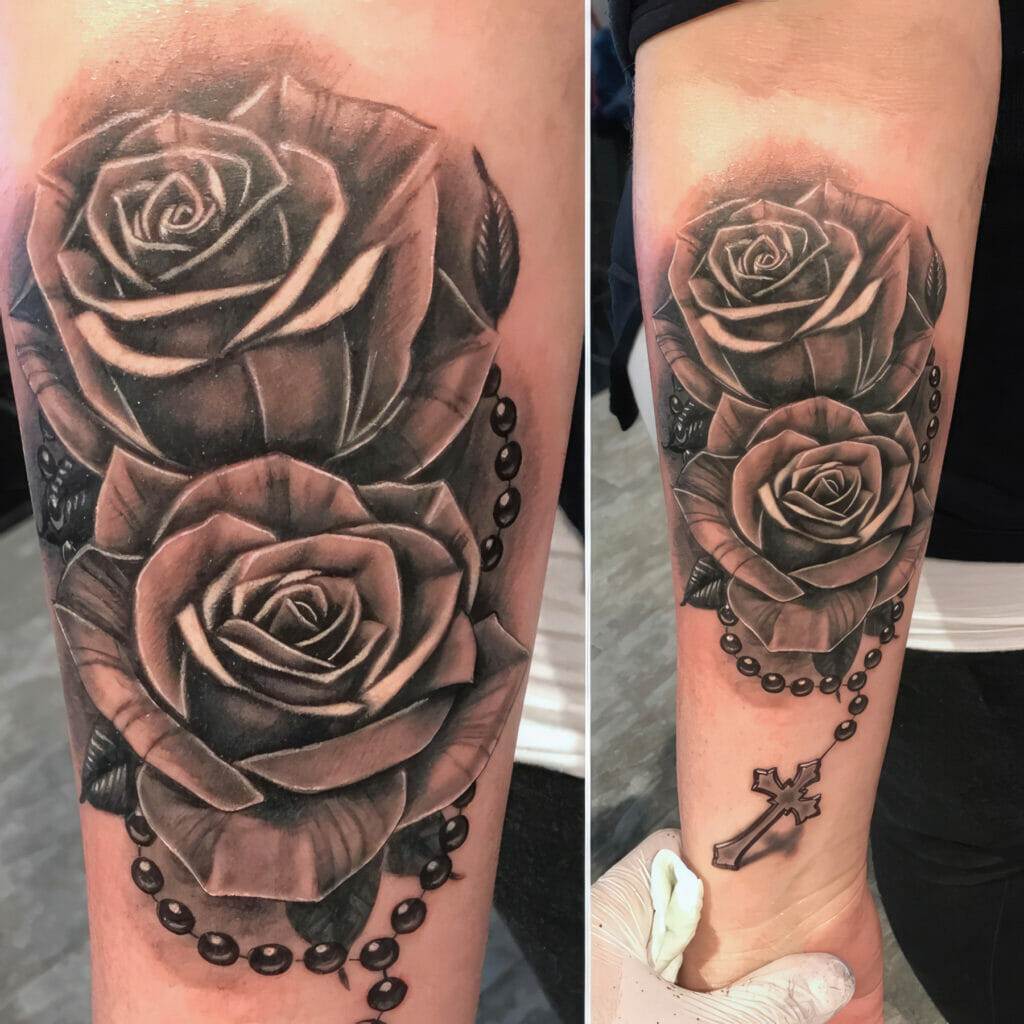 A black and grey rose tattoo with a rosary.