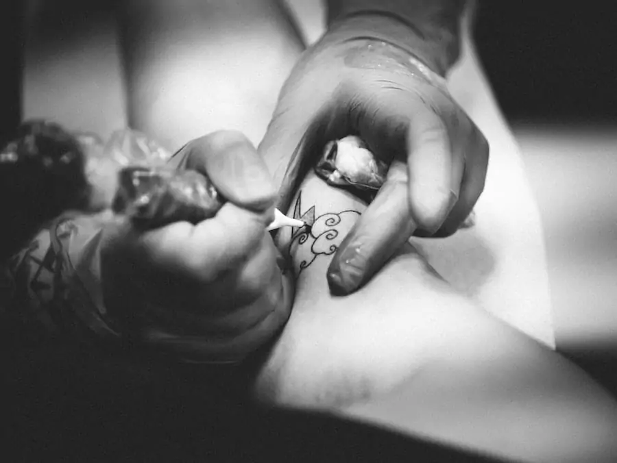A tattoo artist is getting a tattoo on a woman's arm.