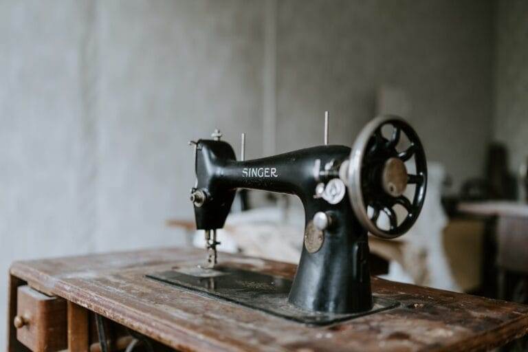 An old sewing machine sits on top of a wooden table.