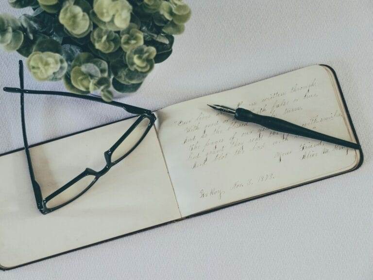 An open notebook with a pen and glasses.