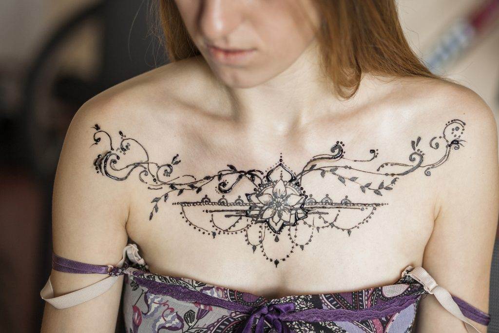 A woman with stunning works of art on her chest.