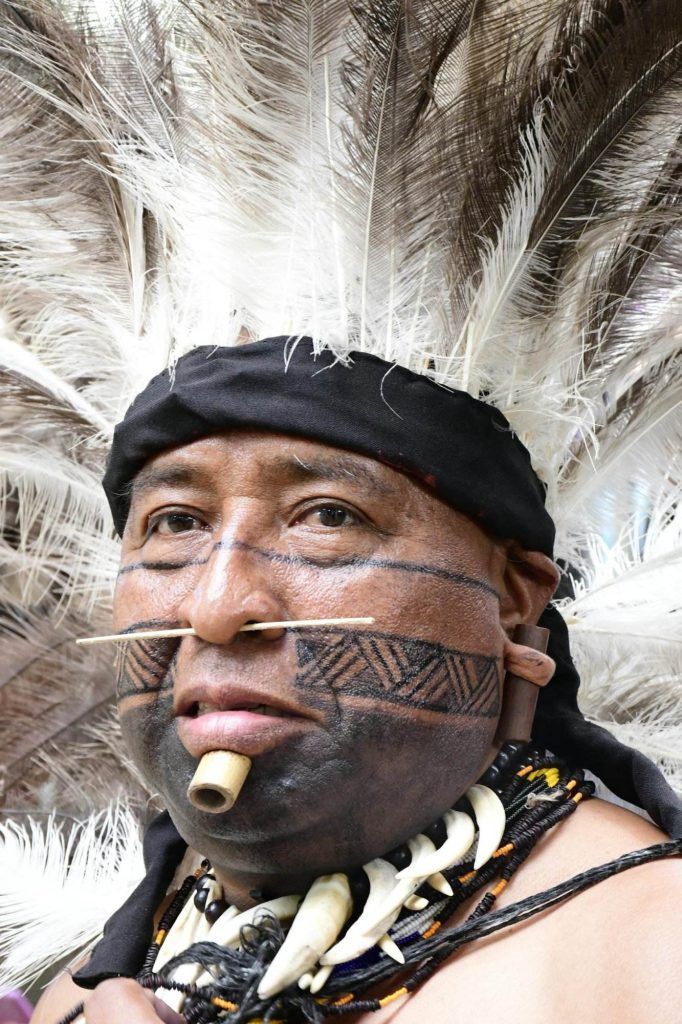 Man in Plume and with Tattoo and Piercing on Face