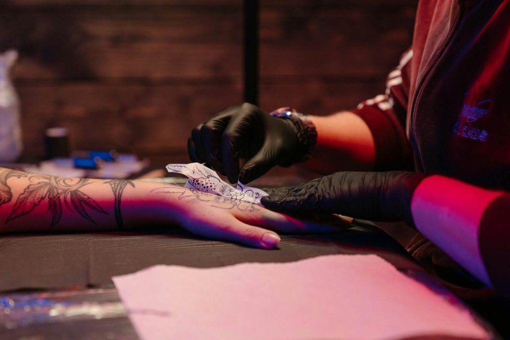 Woman in Black Long Sleeve Shirt and Red Pants Lying on Pink Yoga Mat