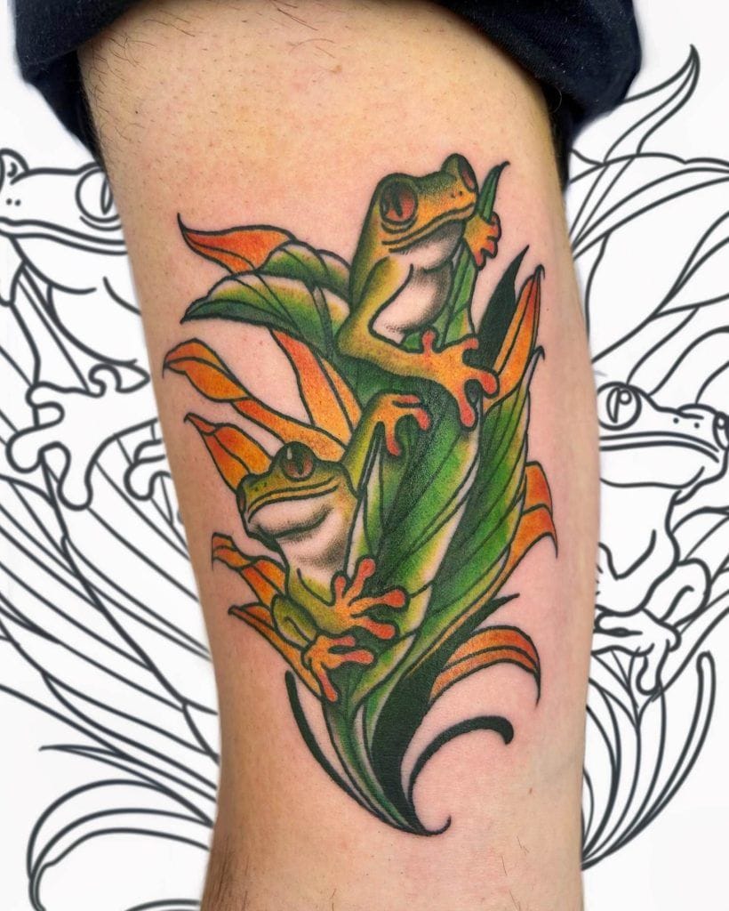 Tattoo of two colorful frogs perched on green and orange leaves, with a black and white frog design in the background.
