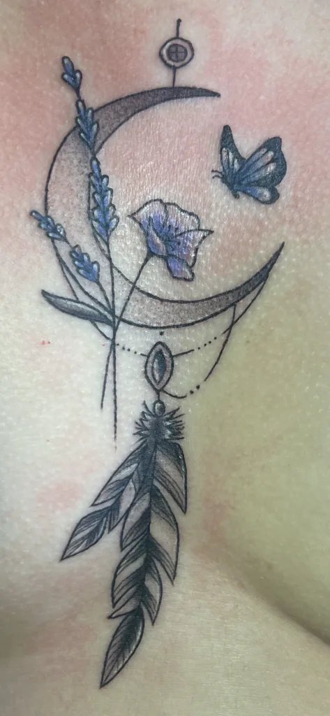Tattoo of a crescent moon, lavender sprig, butterfly, and feather with geometric elements.