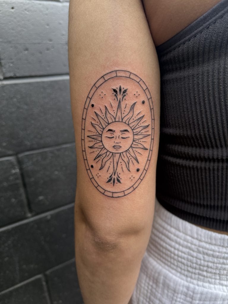 Sun with a face, surrounded by an oval frame, with decorative lines and dots.