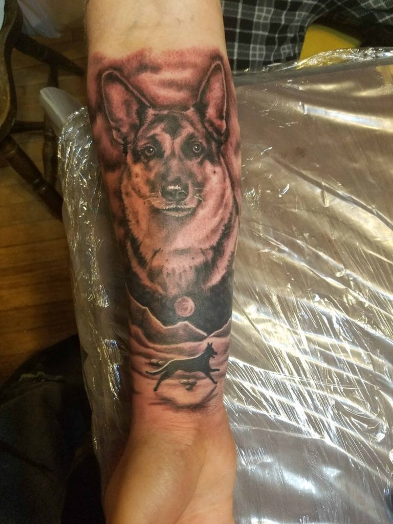 Black and gray tattoo of a dogs face above a running dog silhouette with mountains and a full moon.