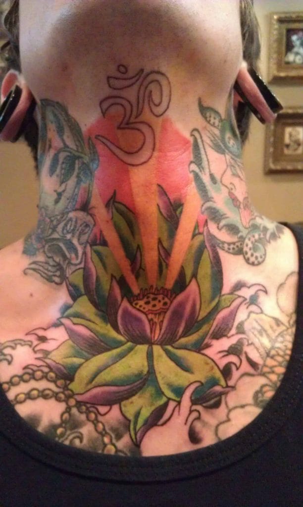 Colorful tattoo of a lotus flower with a yellow center on the neck, surrounded by other designs.
