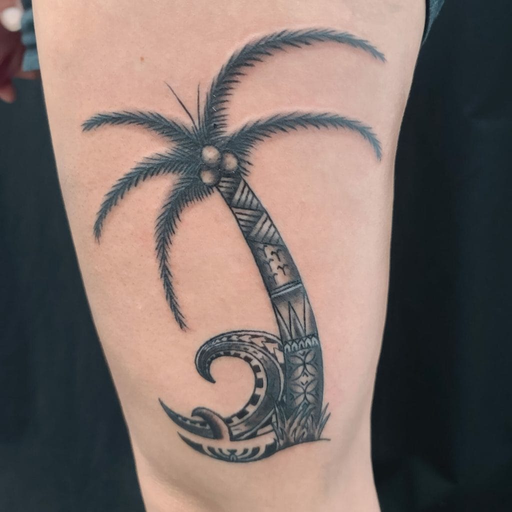 Black and gray tattoo of a palm tree with detailed leaves and coconuts, and a stylized wave at the base.