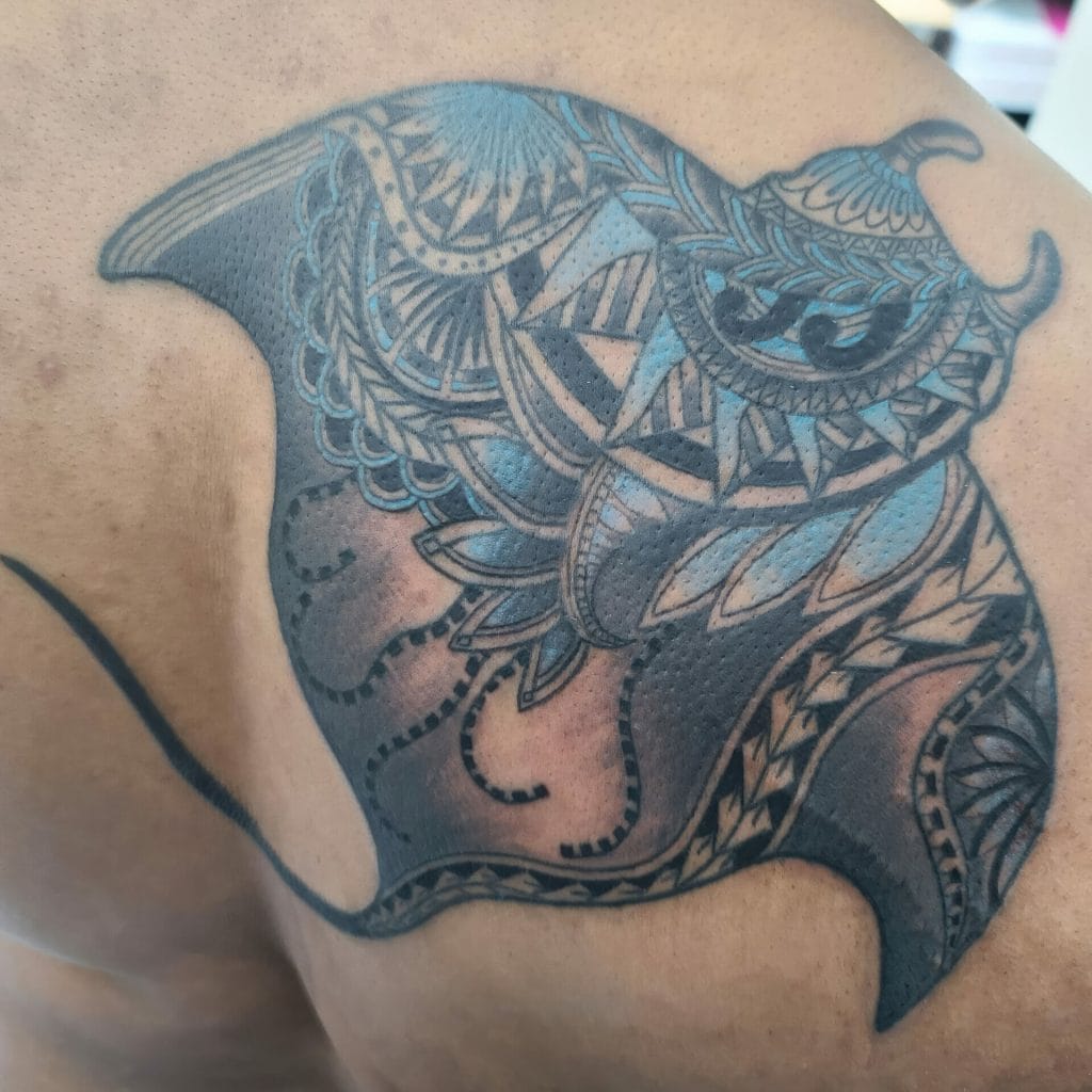 Detailed black and gray tattoo of a stylized owl with intricate geometric and tribal patterns.