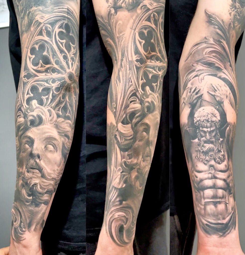 Detailed black and gray tattoo sleeve featuring a bearded mans face, ornate patterns, and a mythological figure.