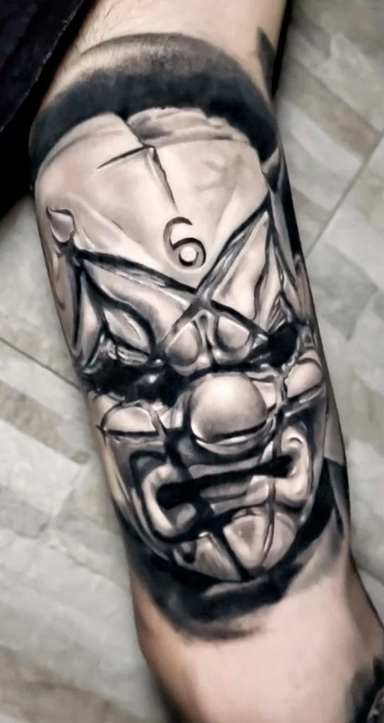 Black and gray realistic tattoo of a clown face with a pentagram on the forehead.