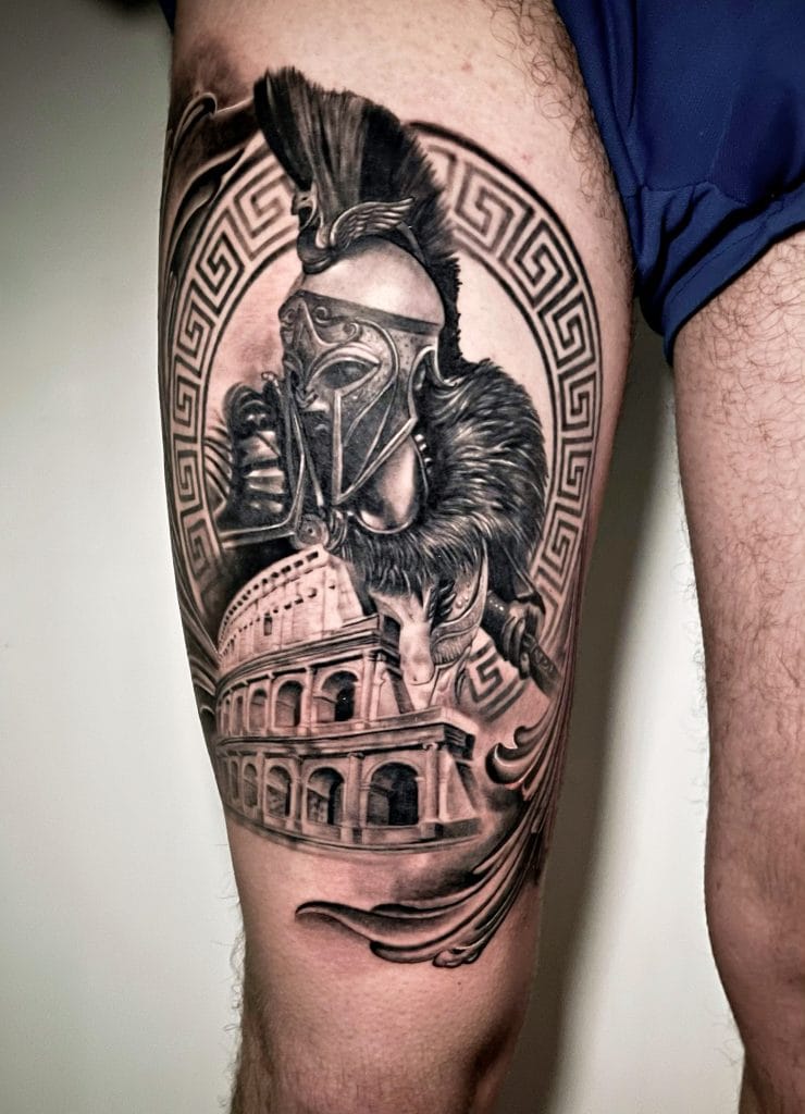 Detailed black and gray tattoo of a Roman soldier with a helmet, lion, and Roman architecture.
