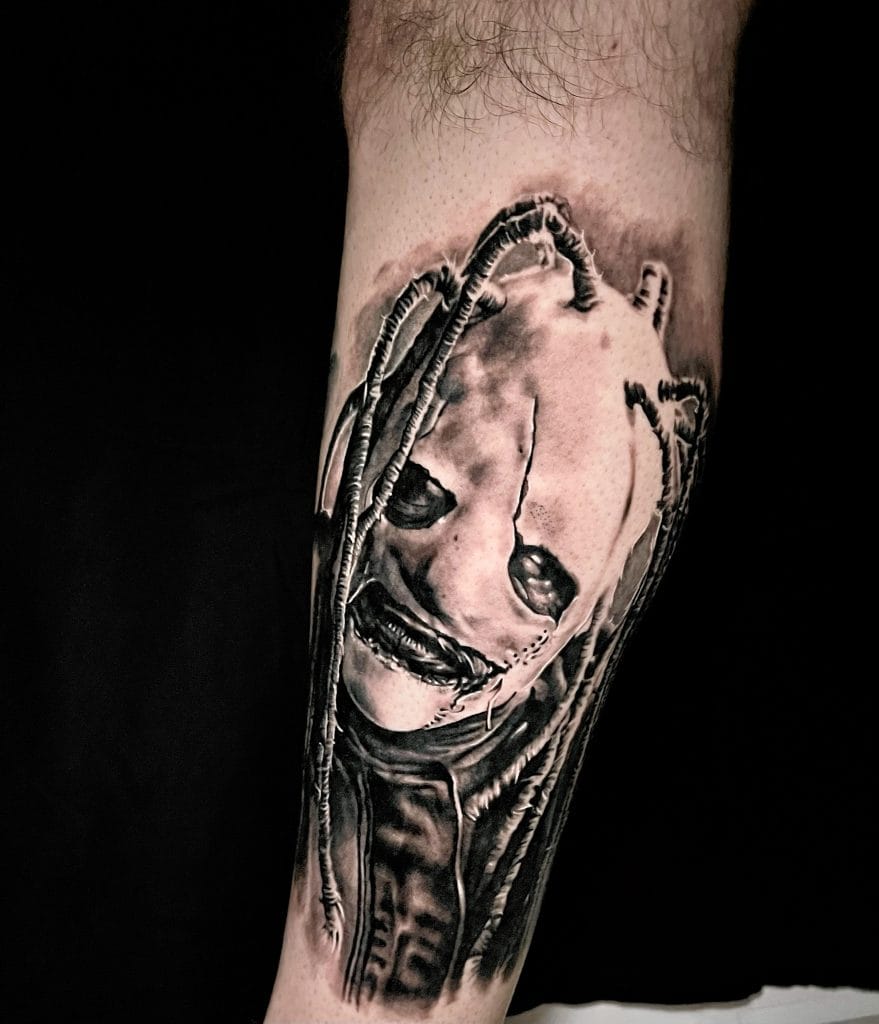 Black and gray realistic tattoo of a smiling womans face with dreadlocks on a persons leg.