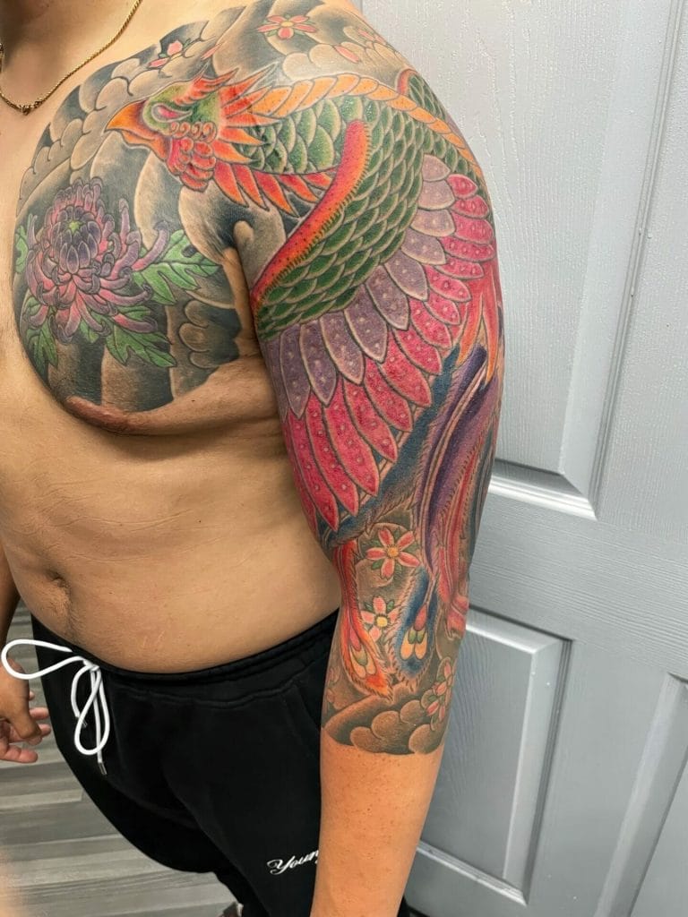 Colorful dragon and floral tattoo covering the shoulder and arm.