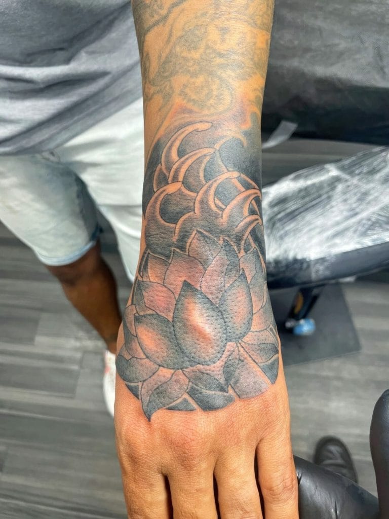 Detailed black and gray tattoo of a succulent plant on the persons forearm.