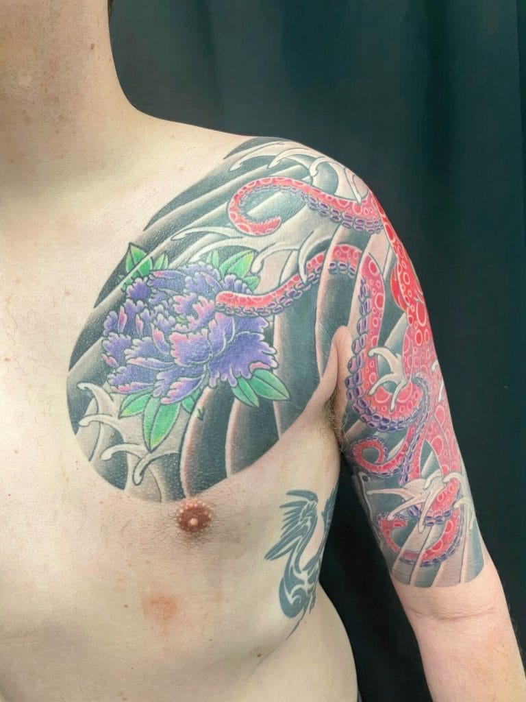 Colorful tattoo of an octopus, purple flowers, and green leaves on the shoulder and arm.