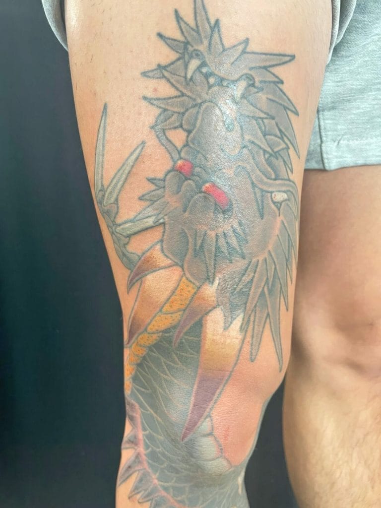 A detailed tattoo of a lions head with a sword, featuring sharp claws and a mane.