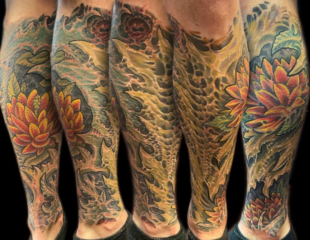 Colorful floral and wave tattoo sleeves covering both arms and shoulders.