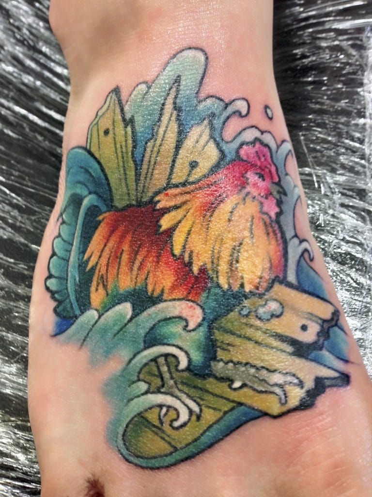 Colorful tattoo of a rooster standing on a skateboard with waves in the background.