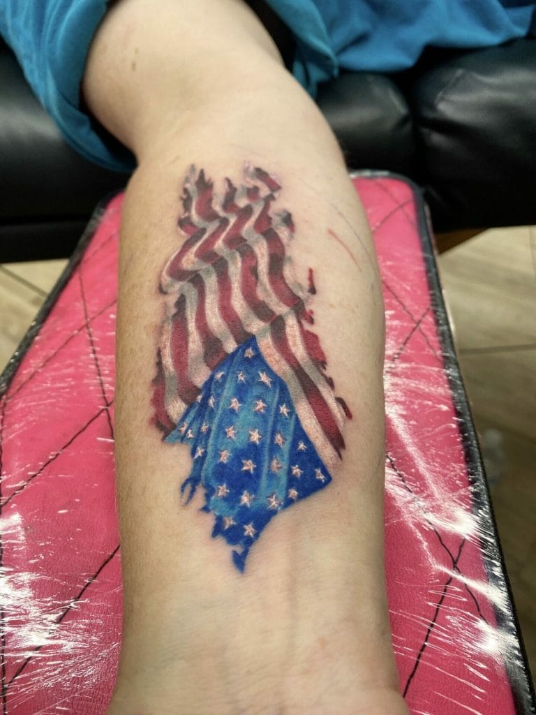 Tattoo of tattered American flag with waving red and white stripes and blue field with white stars.