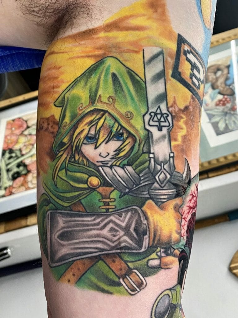 Colorful tattoo of Link from The Legend of Zelda holding a sword and shield, with a sunset background.