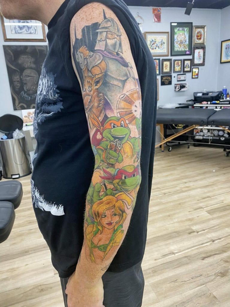 Colorful tattoo sleeve featuring Teenage Mutant Ninja Turtles, a woman, and a knight.