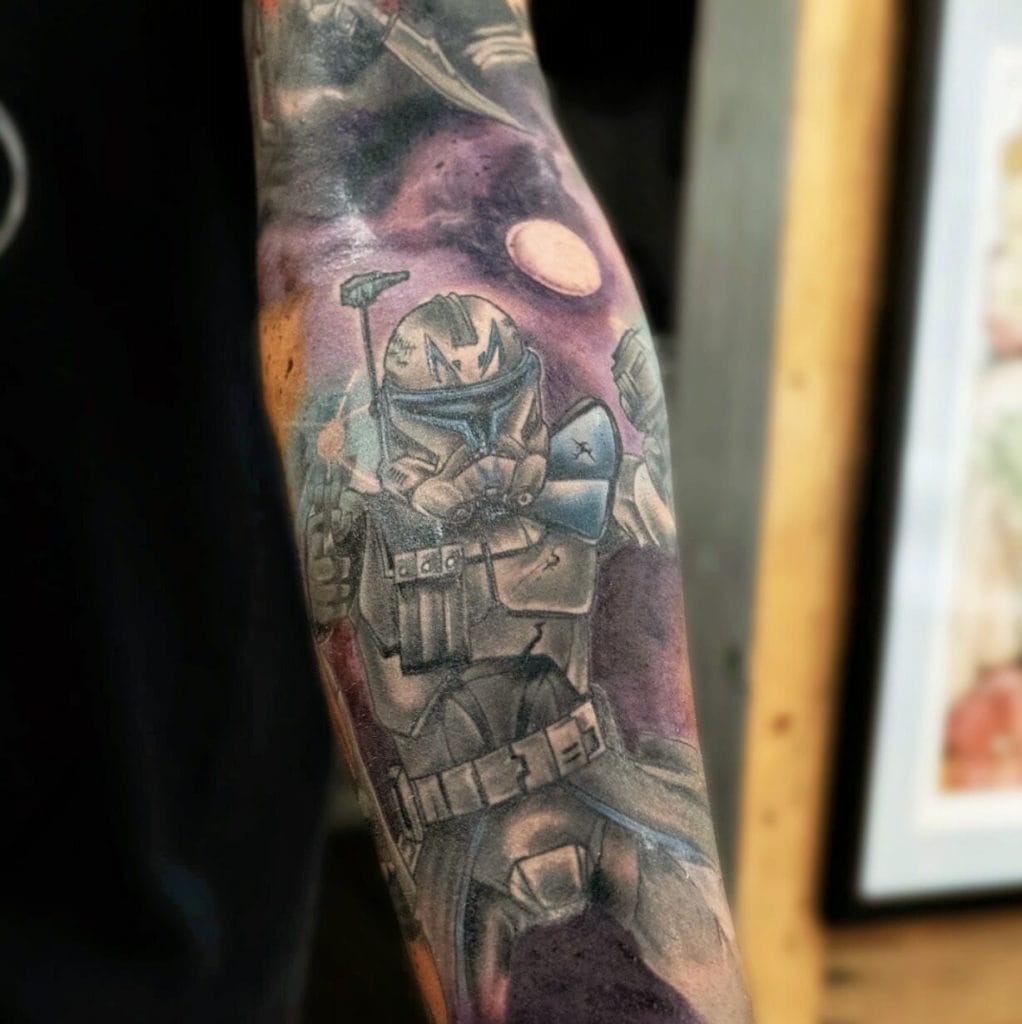 Tattoo of a Mandalorian character in armor, holding a weapon, with a space background.