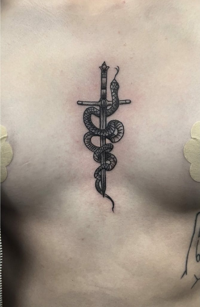 A tattoo of a sword intertwined with a snake on a persons chest.
