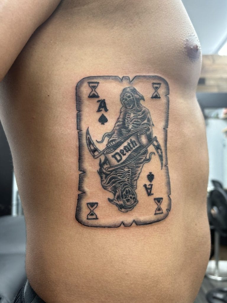 Tattoo of a grim reaper holding a scythe and a sickle, with Death written across the blade.