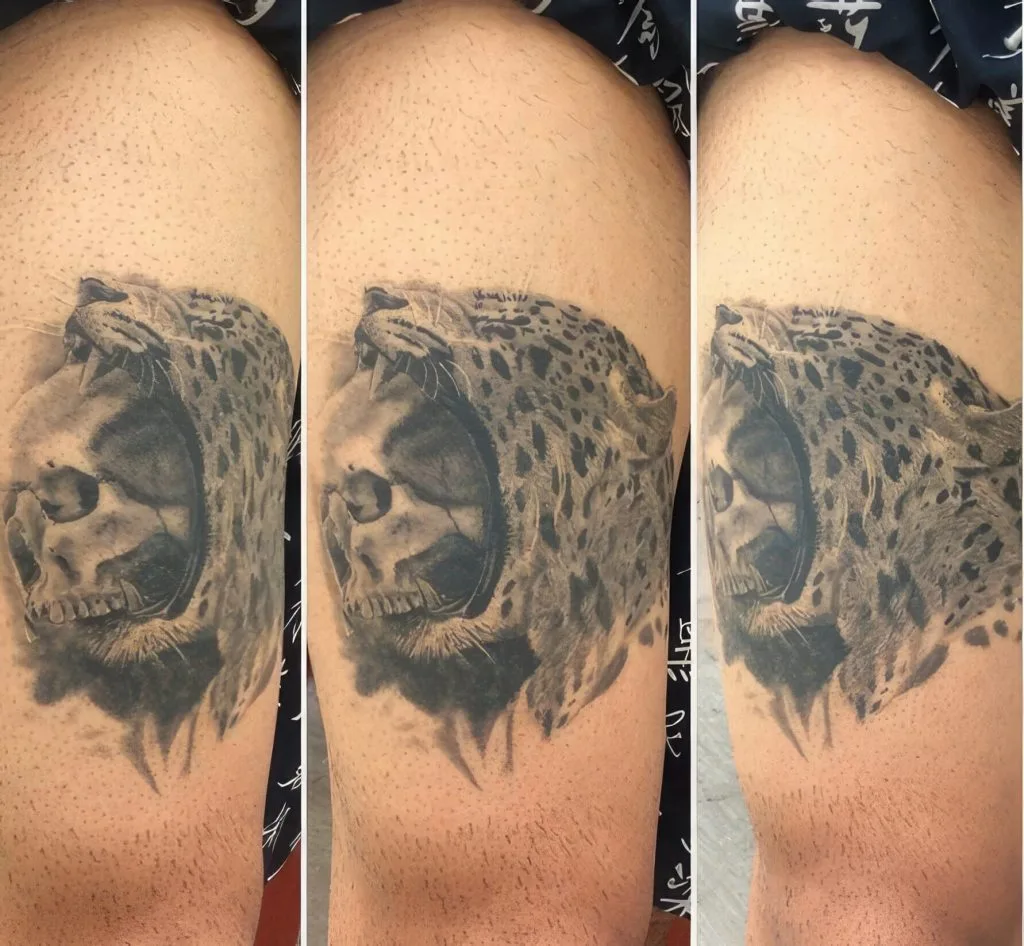 Tattoo of a leopards face with a skull inside, on persons upper arm.