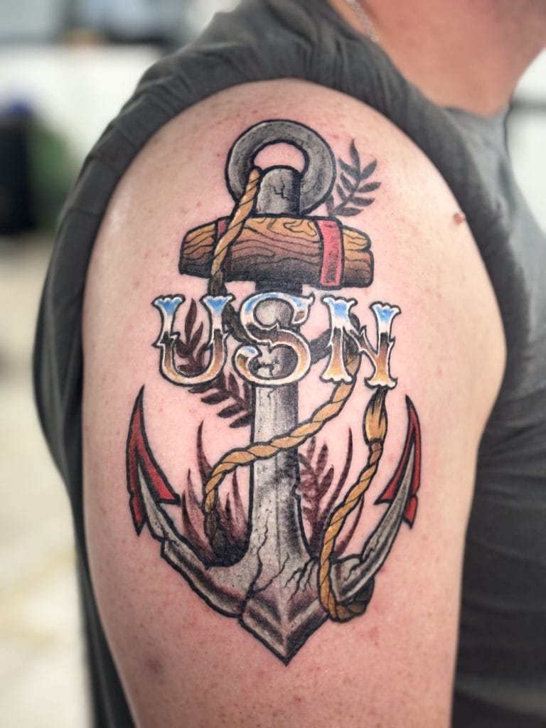 Anchor with rope and leaves, and the letters USN above, on a persons upper arm.