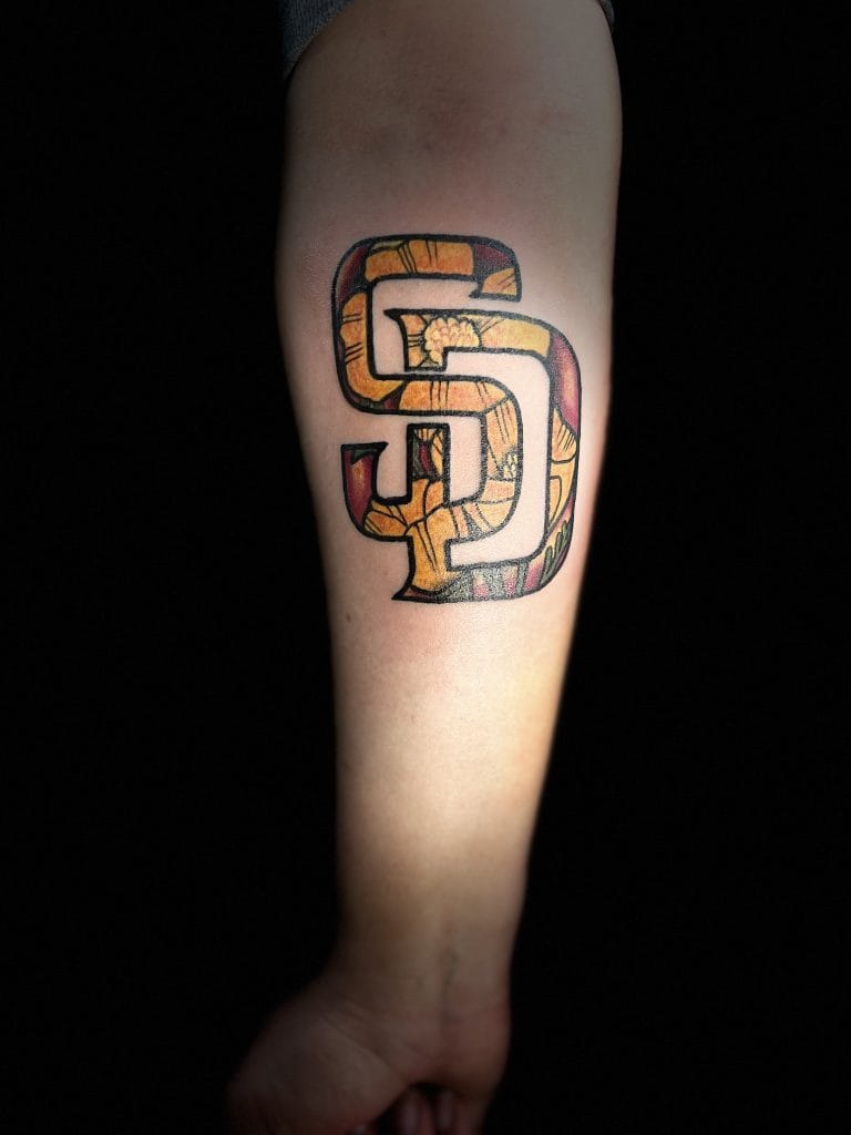 Colorful geometric snake tattoo on inner forearm with black outline and shading.